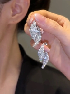 Macro shot of silver needle geometric earrings with shimmering pave-set cubic zirconia