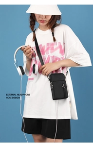 Crossbody phone bag in black nylon with external headphone hole shown on model