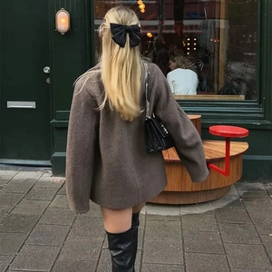 Street style view of a brown wool short coat with tailored silhouette and textured fabric
