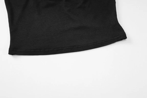 Détail de l'ourlet à double couture sur une robe courte noire et texture du tissu en gros plan