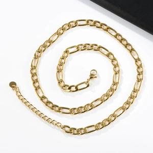 Macro shot of gold stainless steel Figaro chain with lobster clasp and extension link