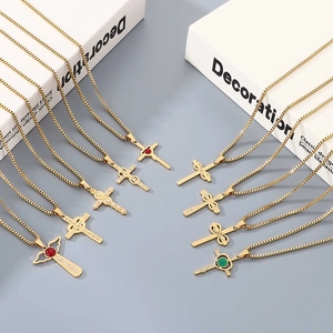 Set of nine golden stainless steel cross necklaces with crystals and pearls on grey background