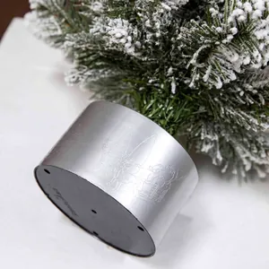 Miniature flocked Christmas tree with silver reindeer base showing intricate carving