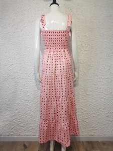 Detail of pink printed maxi dress featuring a smocked back and adjustable bow straps