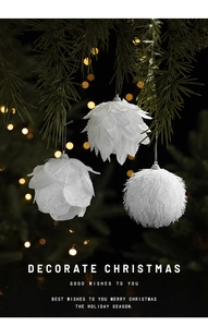 Close-up of white pinecone and plush foam ornaments with glitter on a Christmas tree branch