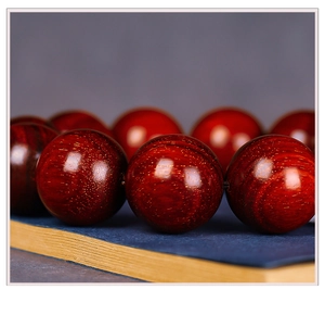 Detailed macro view of red sandalwood beads showing dense gold star textures on wood surface