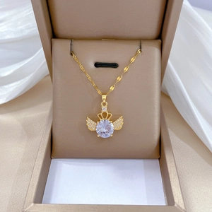 Detailed close-up of golden angel wing and crown pendant with micro-pave crystals