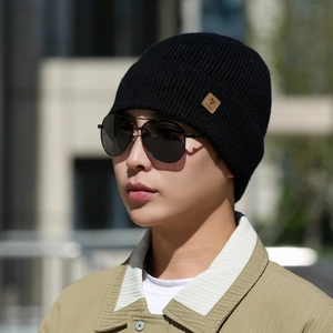 Men's winter ribbed knit beanie in black featuring a brown leather logo patch
