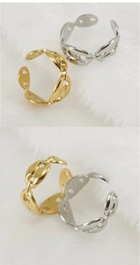Detalle de anillos de grano de café en oro y plata sobre un fondo de peluche blanco suave