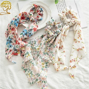 Detailed view of three floral chiffon scrunchies with long silk-like ribbon streamers
