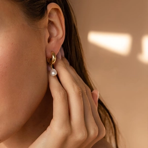 14K gold plated hoop earrings with freshwater pearls on model in natural sunlight