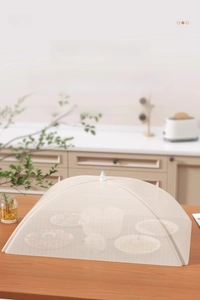 Close-up of foldable mesh food cover on wooden table for dust and insect protection