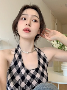 Close-up of minimalist silver heart earrings and pearl chain necklace on model