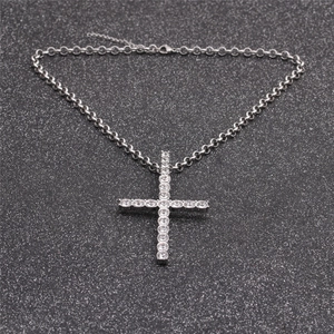 Icy silver hip hop cross necklace with sparkling clear rhinestones on a dark textured background