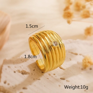 Detailed view of 18K gold plated wide band ring with cubic zirconia on textured rock