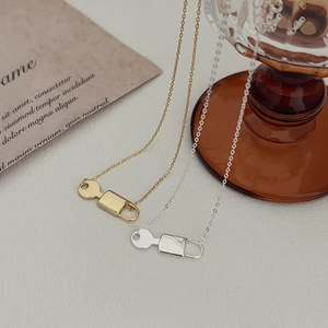 Macro detail of minimalist 925 silver key pendant necklace in gold and silver finish