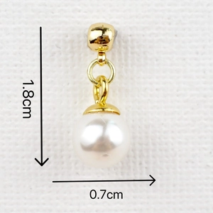 Macro shot of gold charm with a 0.7cm white pearl and dimensions shown in detail