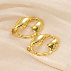 Boucles d'oreilles gouttes dorées irrégulières et évidées sur fond de satin
