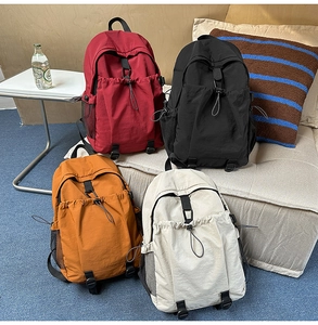 Detailansicht von vier großen Nylon-Rucksäcken in Burgund, Schwarz, Gelb und Cremeweiß
