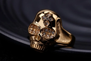 Macro shot of gold stainless steel skull ring with sparkling zircon inlays in eyes