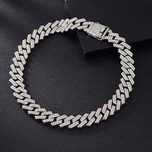 Macro detail of silver Cuban chain necklace with sparkling rhinestones on black texture