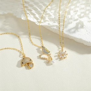 Close-up of gold necklaces with mushroom, butterfly, and floral pendants with pearls