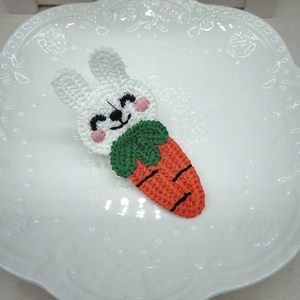 Dettaglio di un fermaglio per capelli all'uncinetto con coniglio bianco e carota