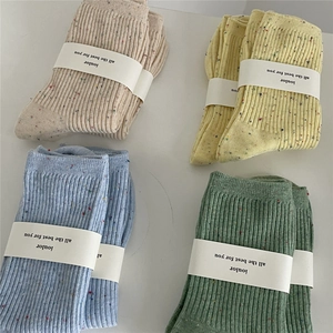 Flat lay of four pairs of ribbed cotton crew socks in pastel colors with nep yarn texture
