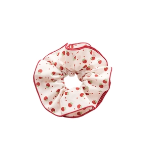 Floral strawberry print scrunchie with red edges on minimalist white background