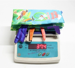 Detail view of baby ocean cloth book being weighed on a scale showing 37.4 grams weight