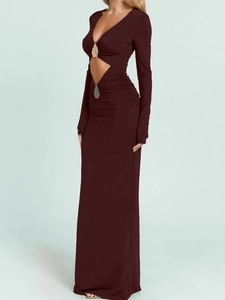 Detail of deep red-brown long sleeve maxi dress featuring waist cut-out and metal ring