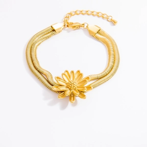 Detail eines goldenen zweischichtigen Schlangenkette-Armbands mit Gänseblümchen-Anhänger