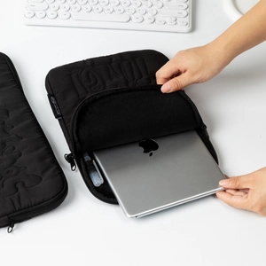 Quilted black laptop sleeve detail with internal pen holder and plush lining