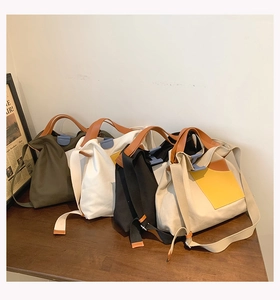 Four colors of canvas tote bags in army green, white, black and beige on wooden table