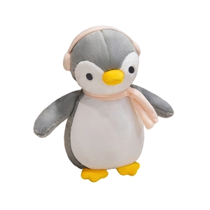 Cute penguin plush toy wearing pink winter scarf and earmuffs on a white background