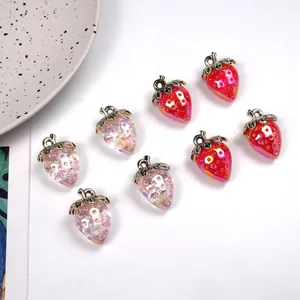 Macro detail of acrylic strawberry charms with silver leaf for DIY jewelry making