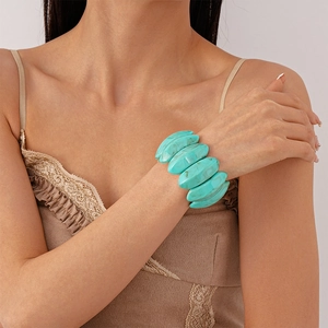 Detailansicht eines markanten türkis marmorierten Acryl-Gliedarmbands am Handgelenk