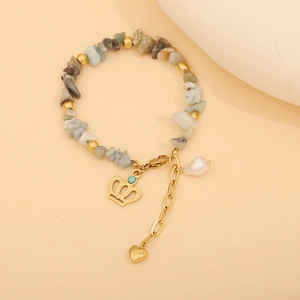 Detail of beaded gemstone bracelet with gold heart pendant and turquoise accents