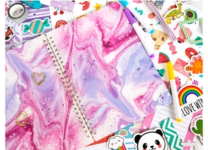 Flat lay of purple marble spiral notebook with golden heart clips and stickers