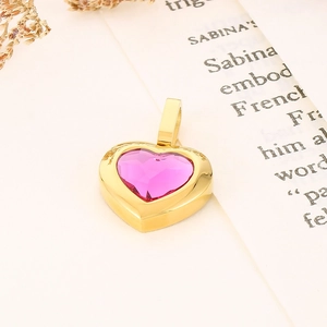 Macro shot of a luxury heart-shaped pink crystal pendant with a polished gold metal frame