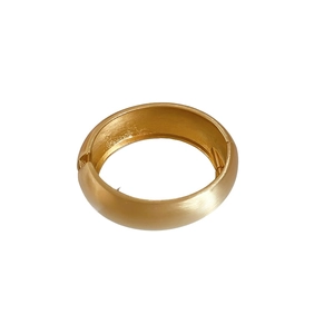 Minimalist wide brushed gold open bangle bracelet with a polished inner surface