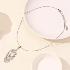 Macro detail of leaf pendant necklace in 304 stainless steel on a white display plate