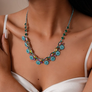 Close-up of vintage palace style necklace with colorful rhinestones on a satin dress