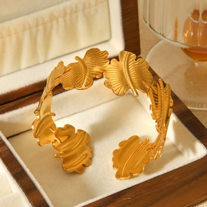 Detailansicht eines 18K Gold-Blattarmreifens mit mattem Finish in einer Holz-Schmuckschatulle