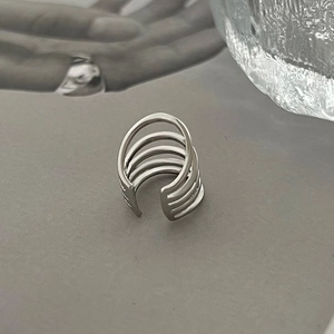 Macro detail of silver layered U-shaped ear cuffs with a minimalist geometric hollow design