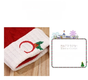 Close-up of red knitted Christmas stocking with white cuff and embroidered letter C