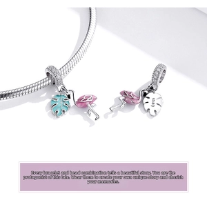 Macro detail of S925 sterling silver flamingo and monstera leaf charm with enamel finish