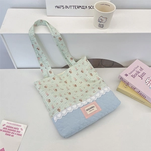 Close-up of quilted tote bag with cute rabbit print and delicate white lace detailing