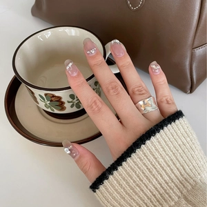 Close-up of irregular silver wave ring with hammered texture on woman's finger