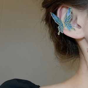 Detail of blue and gold butterfly ear cuff worn on the ear bone for women